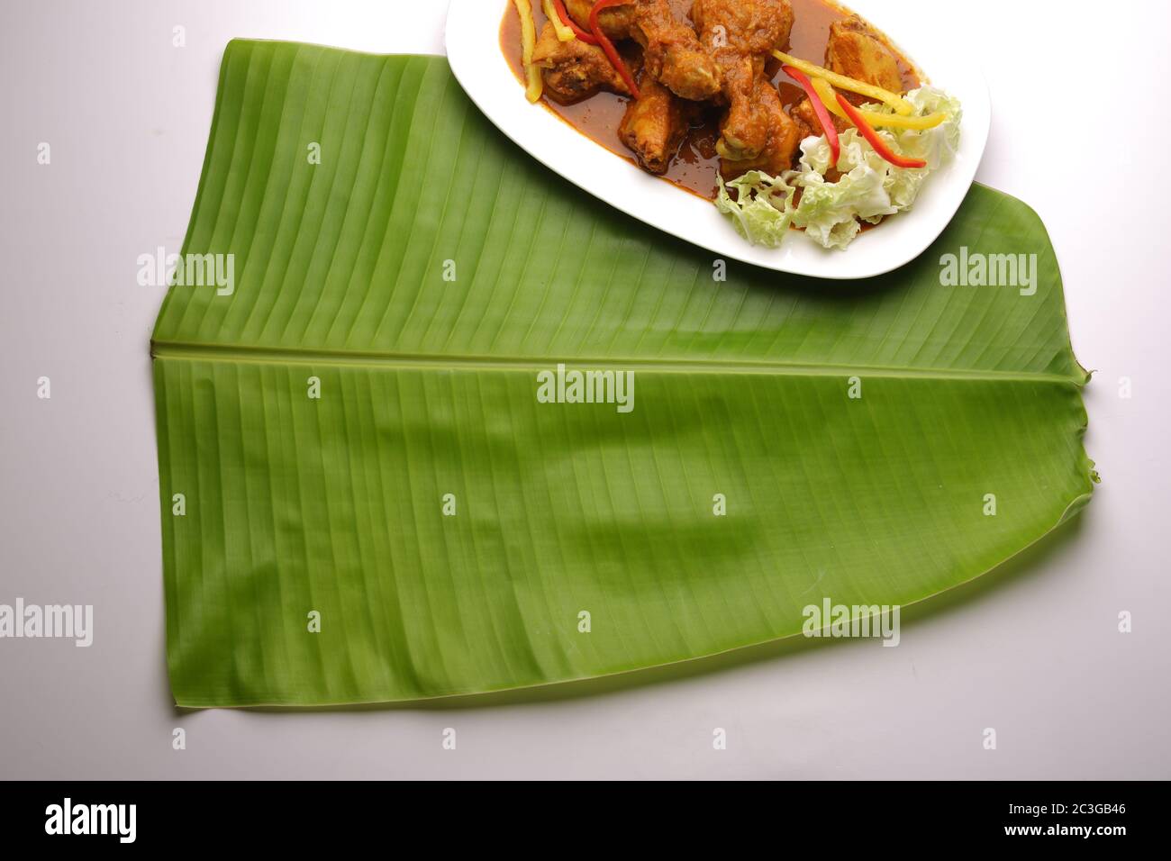 Foglia di banana , foglia di Kerala sadya, un piatto tradizionalmente utilizzato durante la festa e le feste, immagine isolata di foglia di banana verde fresco disposto su bianco Foto Stock