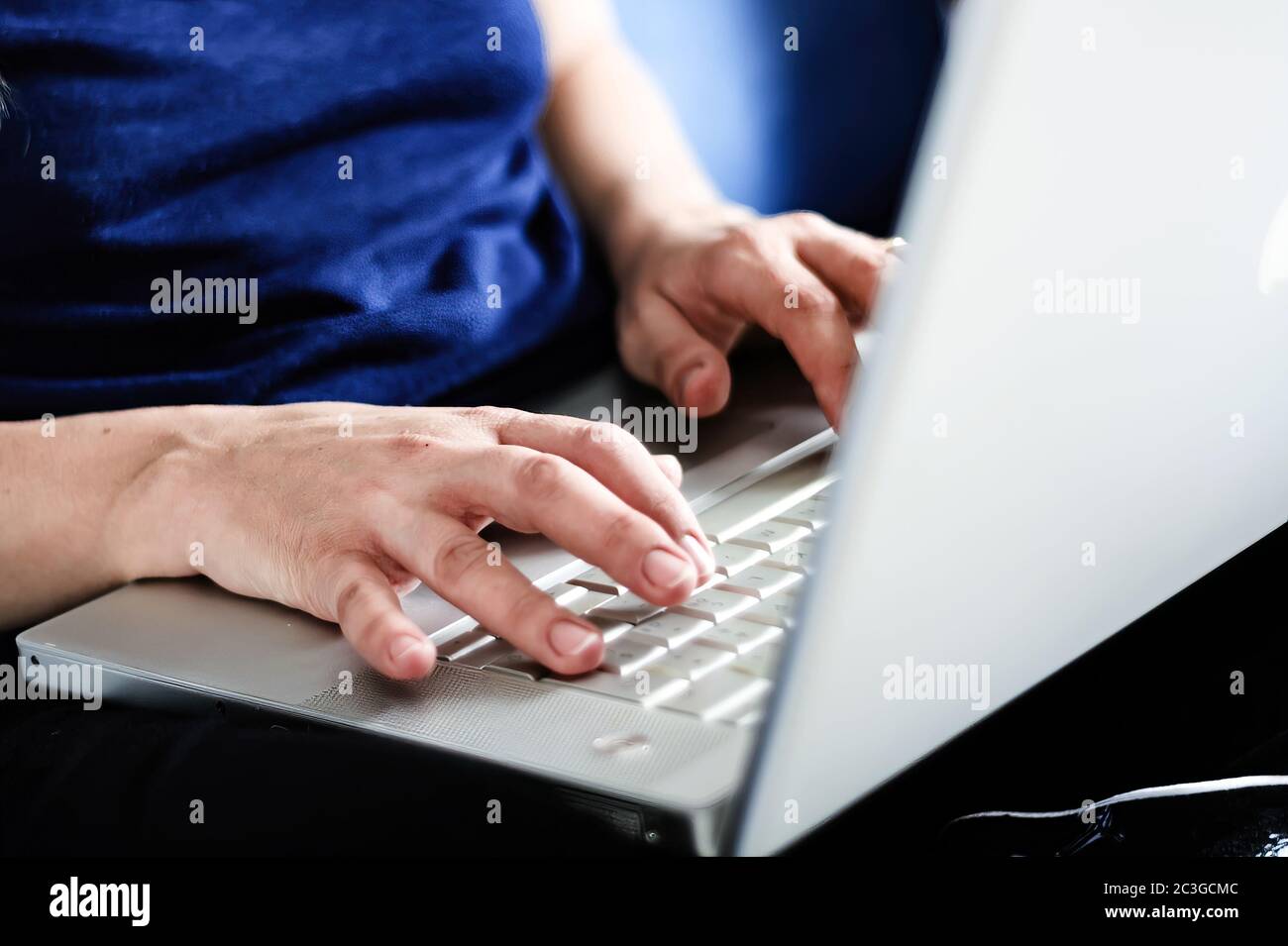 giovane donna caucasica che scrive sulla tastiera del laptop. Lavorare da casa. Concetto di lavoro intelligente Foto Stock