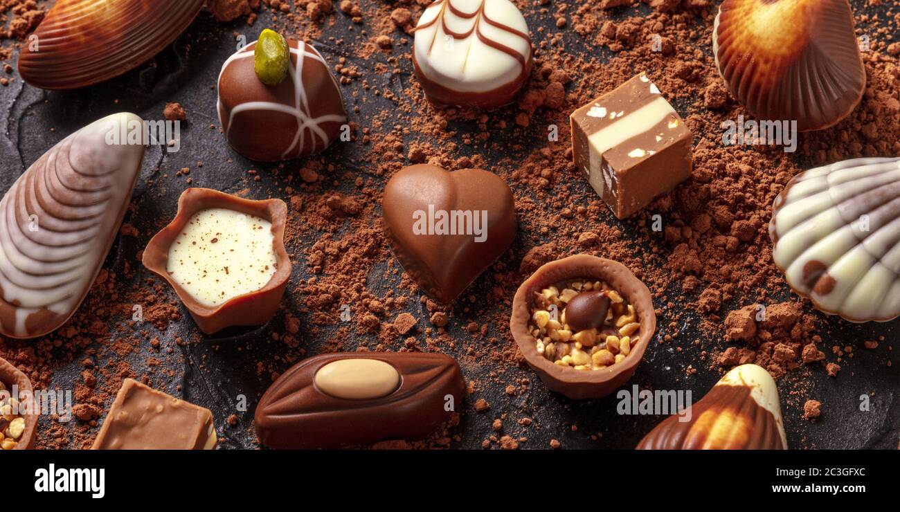 Panorama dell'assortimento di cioccolato belga, vari bonbon su sfondo scuro Foto Stock