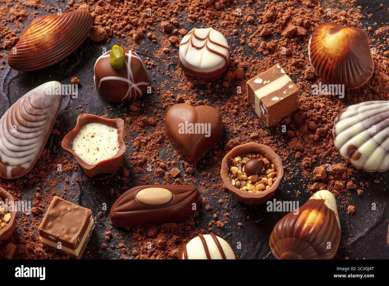 Assortimento di cioccolato belga, molti diversi bonbon su sfondo scuro Foto Stock