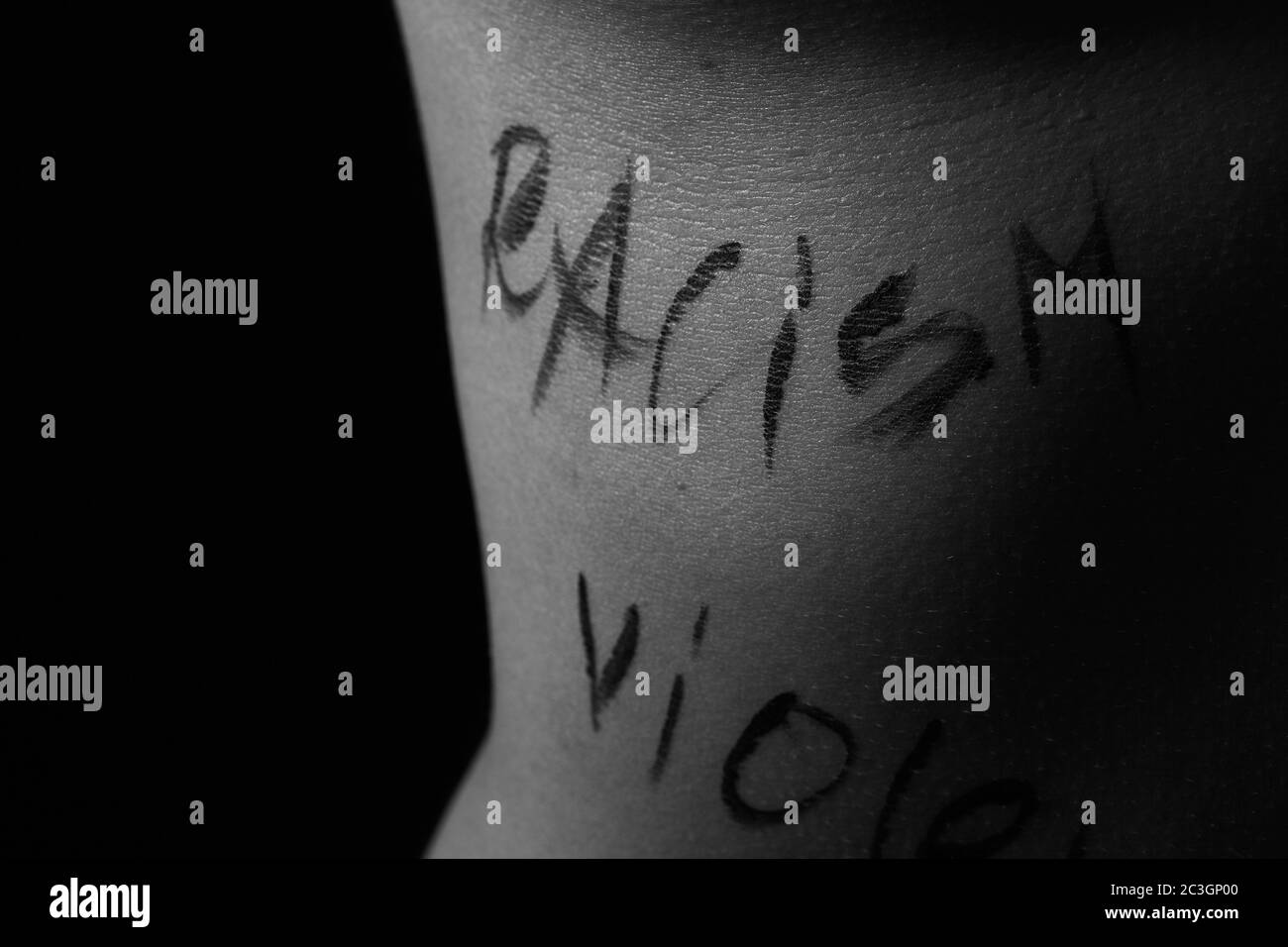 parte del corpo di una giovane ragazza con le parole razzismo. le iscrizioni sono scritte dalla mano del fotografo Foto Stock