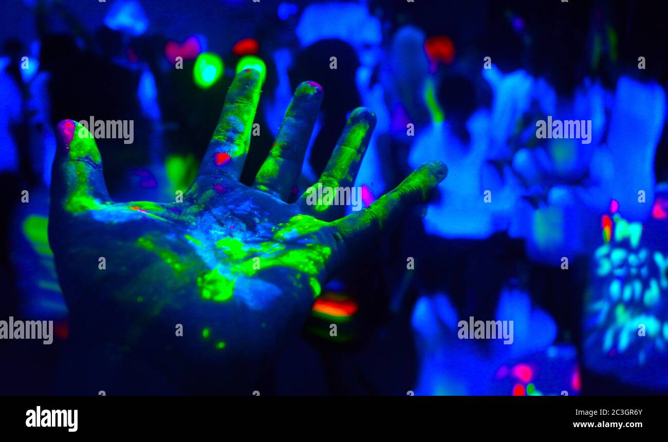Mani coperte di vernice fluorescente Foto Stock