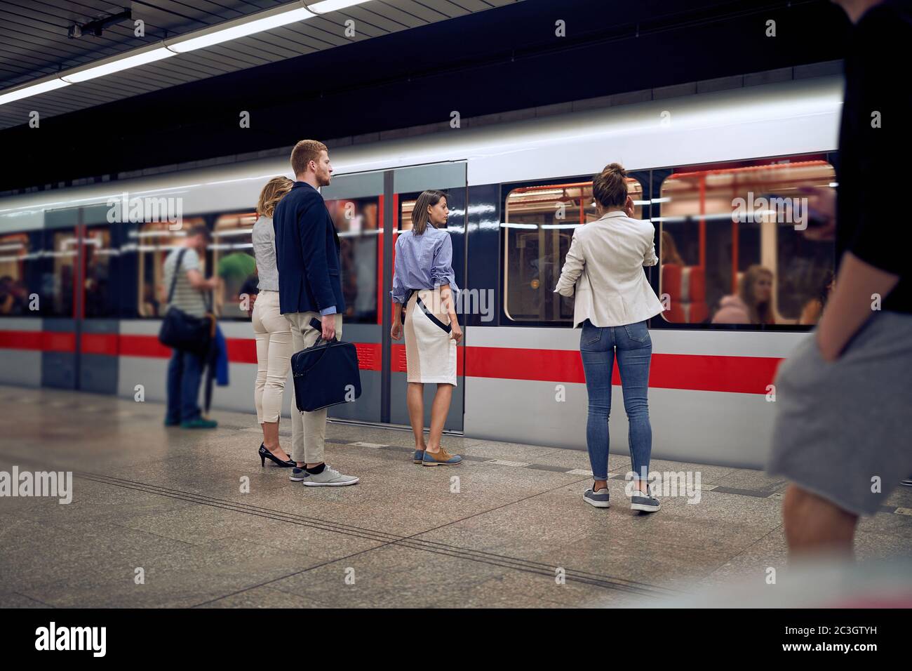 giovani uomini d'affari alla stazione della metropolitana in attesa di un treno. Concetto di tempo Foto Stock
