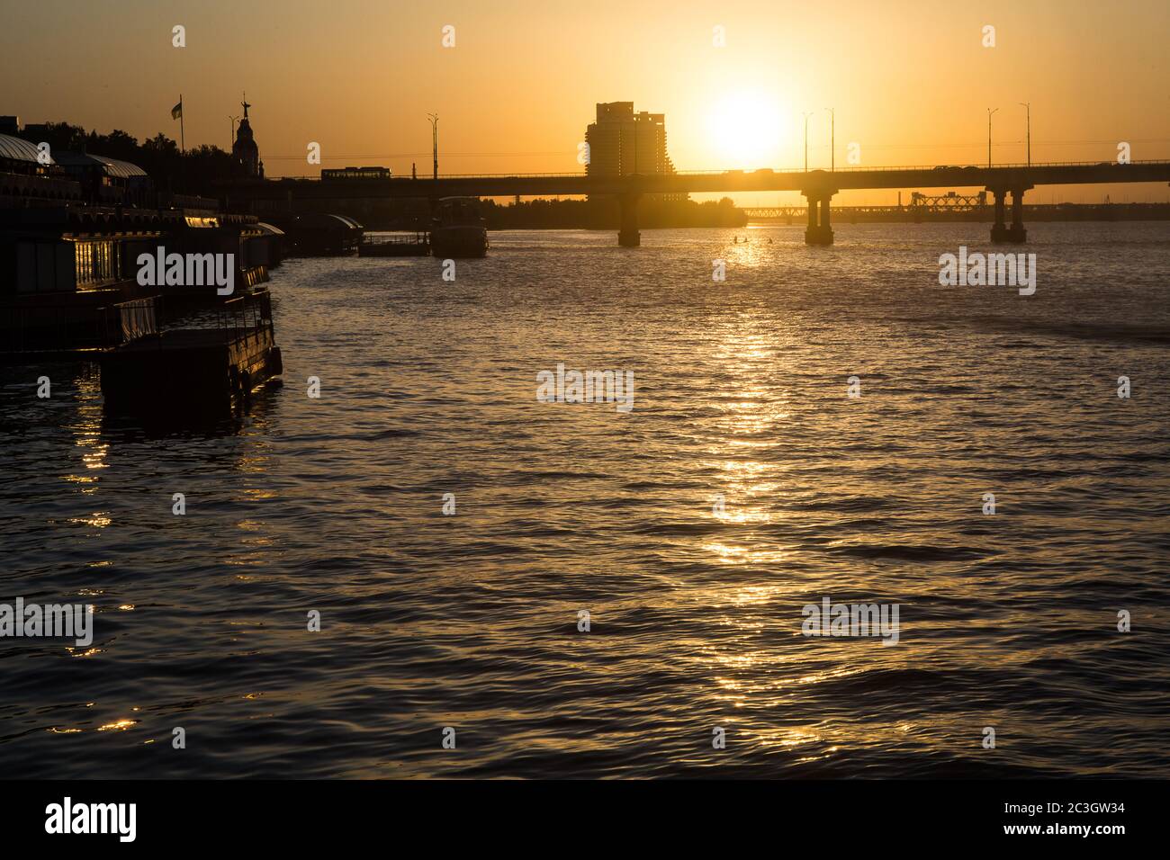 Ricco tramonto estivo colorato a Dnepropetrovsk (Dnept, Dnipro) nel mese di giugno con Parus cantiere incompiuto + due ponti sul fiume nello skyline Foto Stock