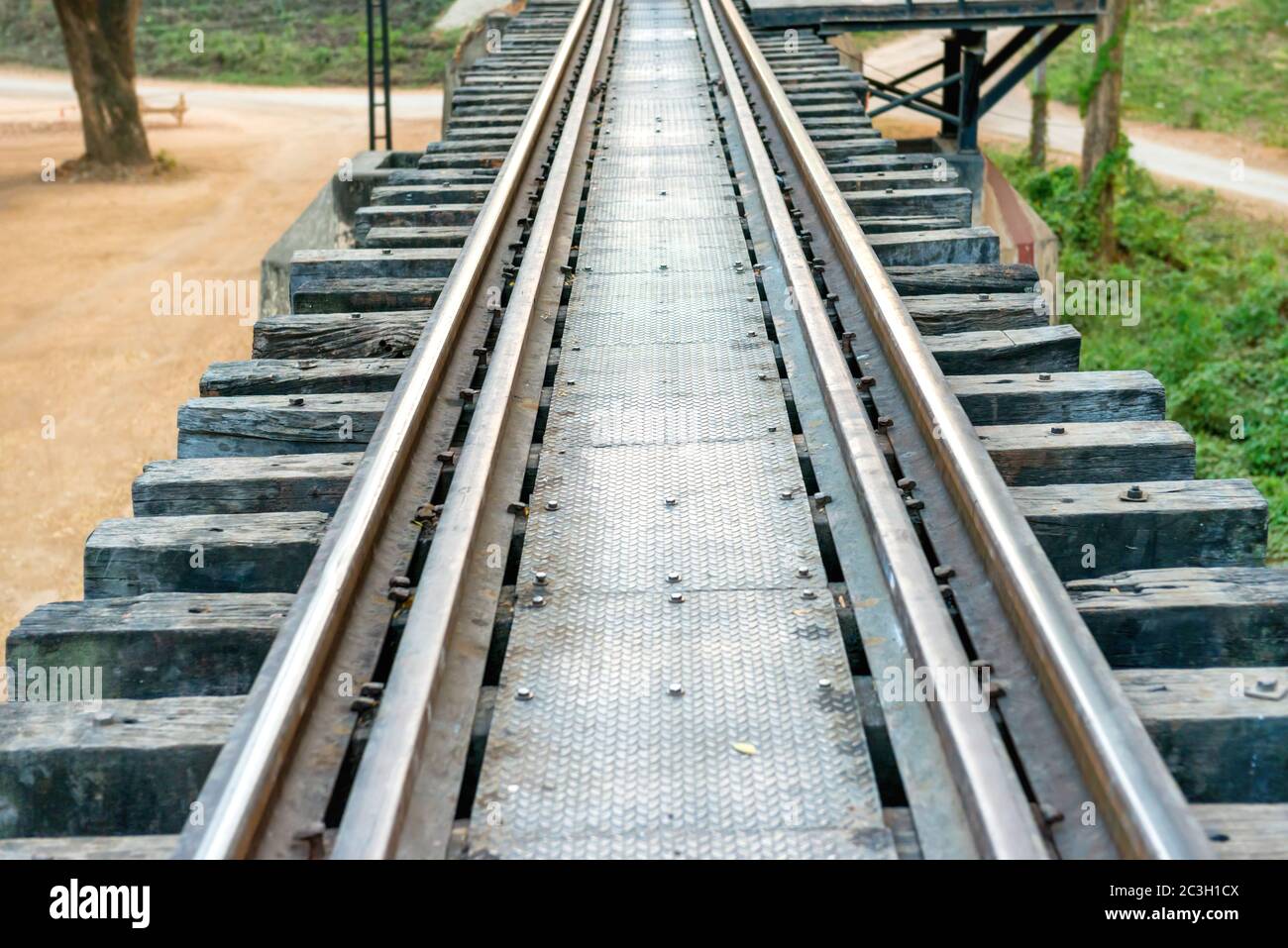 Vecchia pista con traversine di legno e ringhiere arrugginite Foto Stock