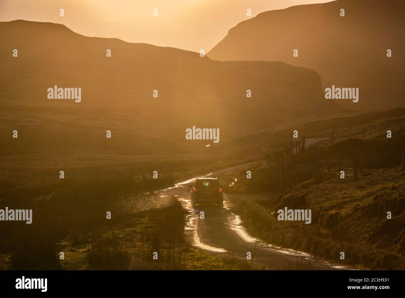 Ora d'oro e sole basso - guidando sull'isola di Skye, Scozia Foto Stock