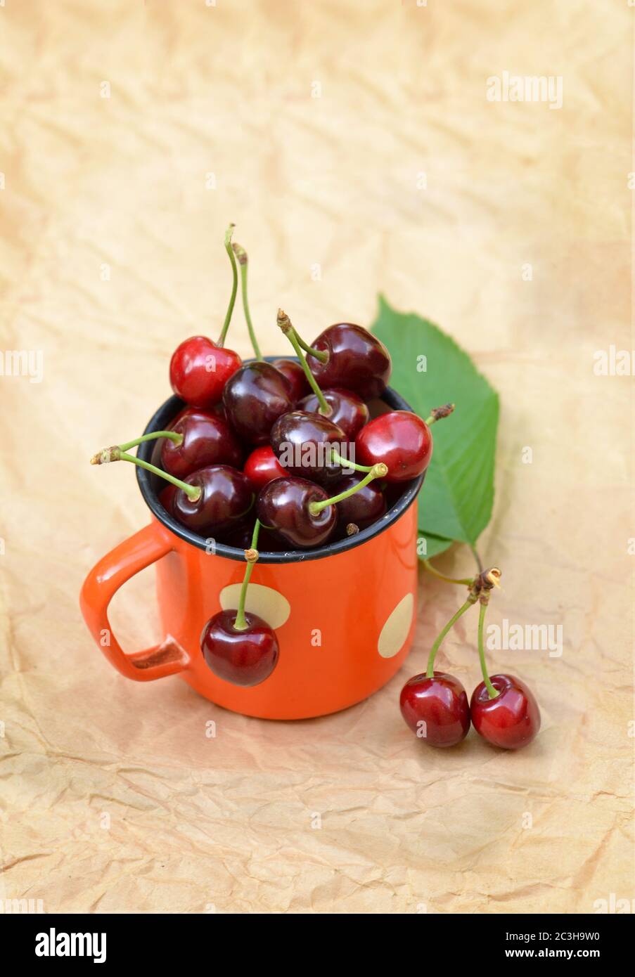 Ciliegie in una tazza di ferro retrò. Foto sul tema delle bacche e cibo da giardino. Foto Stock