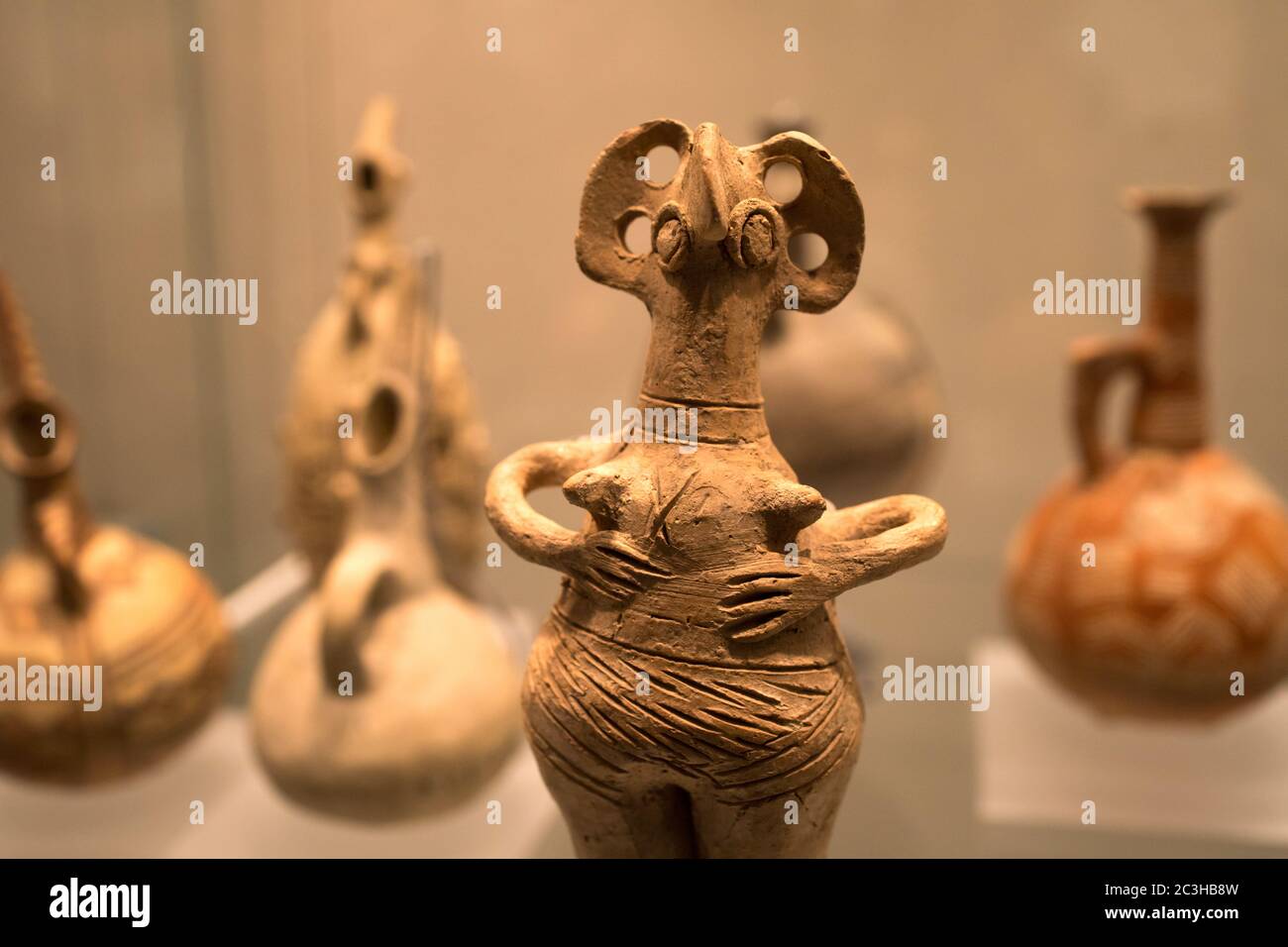 Leiden, Paesi Bassi - 04 GENNAIO 2020: Primo piano di una figurina di terracotta dell'antica Cipro con vecchi vasi sullo sfondo. Foto Stock