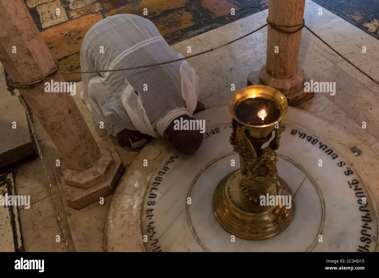 Un pellegrino proveniente dall'Africa prega presso la stazione armena delle Sante donne che commemora Maria (madre di Gesù) e i suoi compagni Maria Maddalena, e Maria di Clopas che ha visto la crocifissione all'interno della chiesa del Santo Sepolcro nel quartiere cristiano, nella città vecchia Gerusalemme est, Israele, nella Chiesa del Santo Sepolcro nel quartiere cristiano, nella città vecchia Gerusalemme est, Israele Foto Stock