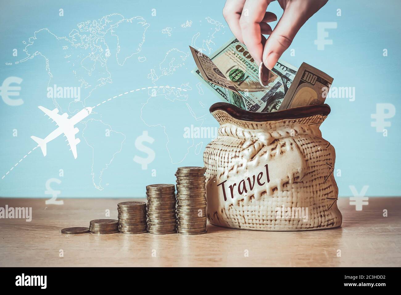 Banconote in dollari USA in borsa con monete Stack on table, sfocare sfondo con icone valuta diversi paesi, la sagoma dell'aereo e il sole del mattino Foto Stock