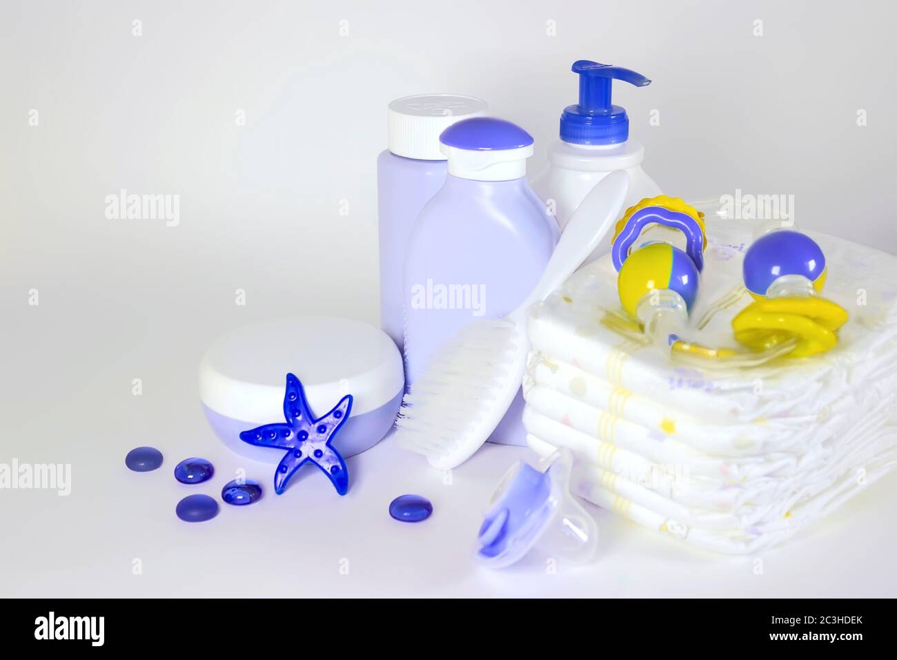 Igiene dei bambini: articoli da bagno, flacone di shampoo, giocattolo in gomma, spugna, pettine, termometro, forbici di sicurezza vista dall'alto, su sfondo blu Foto Stock
