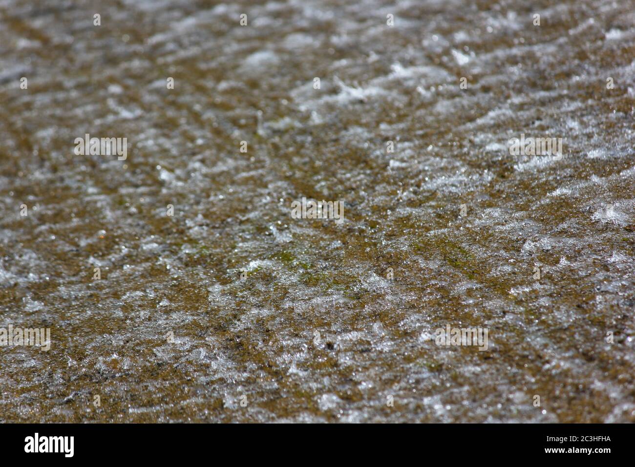 Acqua che scorre su una superficie piana ruvida Foto Stock