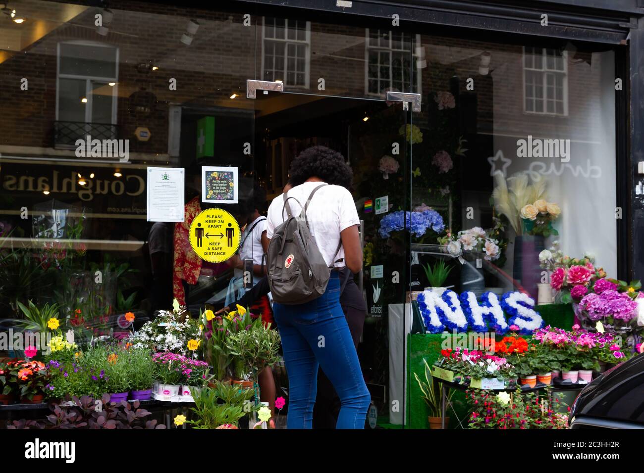 Beckenham, Regno Unito, 20 giugno 2020, la gente segue le regole di allontanamento sociale mentre accodano per andare nei negozi in Beckenham High Street, Kent. La strada è molto più trafficata ora che molti negozi non essenziali hanno riaperto.Credit: Keith Larby/Alamy Live News Foto Stock