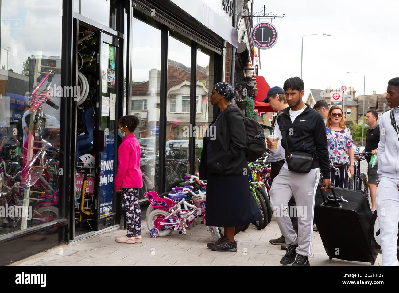 Beckenham, Regno Unito, 20 giugno 2020, la gente segue le regole di allontanamento sociale mentre accodano per andare nei negozi in Beckenham High Street, Kent. La strada è molto più trafficata ora che molti negozi non essenziali hanno riaperto.Credit: Keith Larby/Alamy Live News Foto Stock