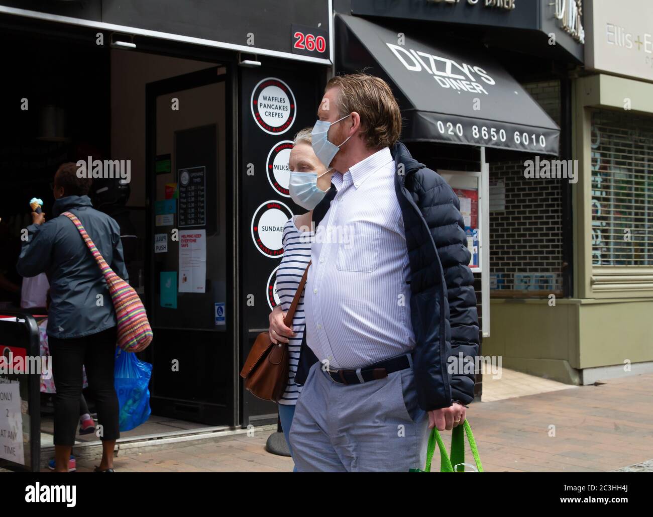 Beckenham, Regno Unito, 20 giugno 2020, la gente segue le regole di allontanamento sociale mentre accodano per andare nei negozi in Beckenham High Street, Kent. La strada è molto più trafficata ora che molti negozi non essenziali hanno riaperto.Credit: Keith Larby/Alamy Live News Foto Stock