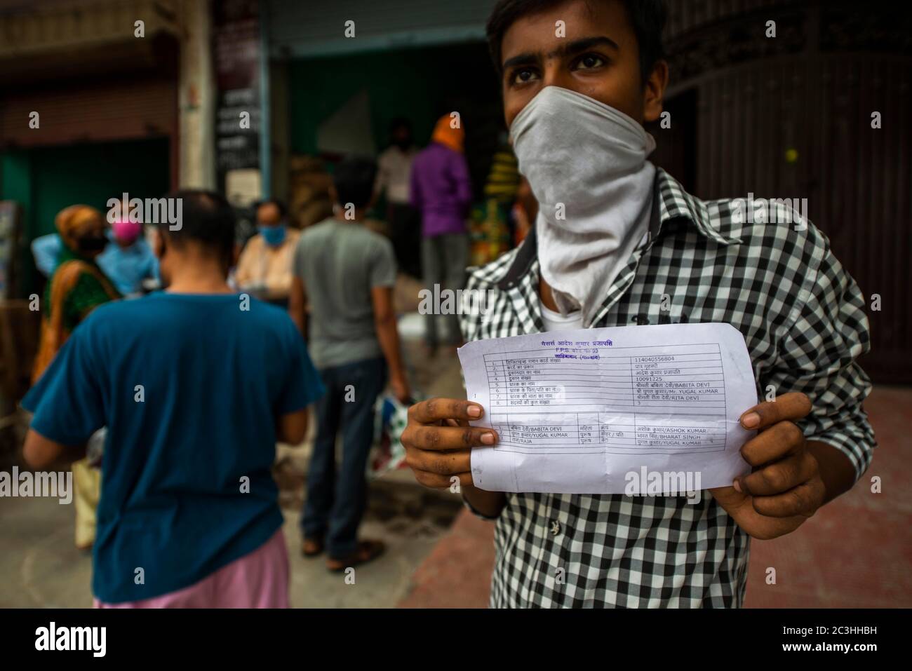 Un uomo che indossa una maschera facciale è visto mostrando la prova della sua razione temporanea card.Government ratation negozi distribuiti 5kg di cibo gratuito sotto il Pradhan Mantri Garib Anna Yojana (PMGAY) durante la crisi Covid-19, finora 39.3 beneficiari crore ottenuto grano in base al National Food Security Act (NFSA). Foto Stock