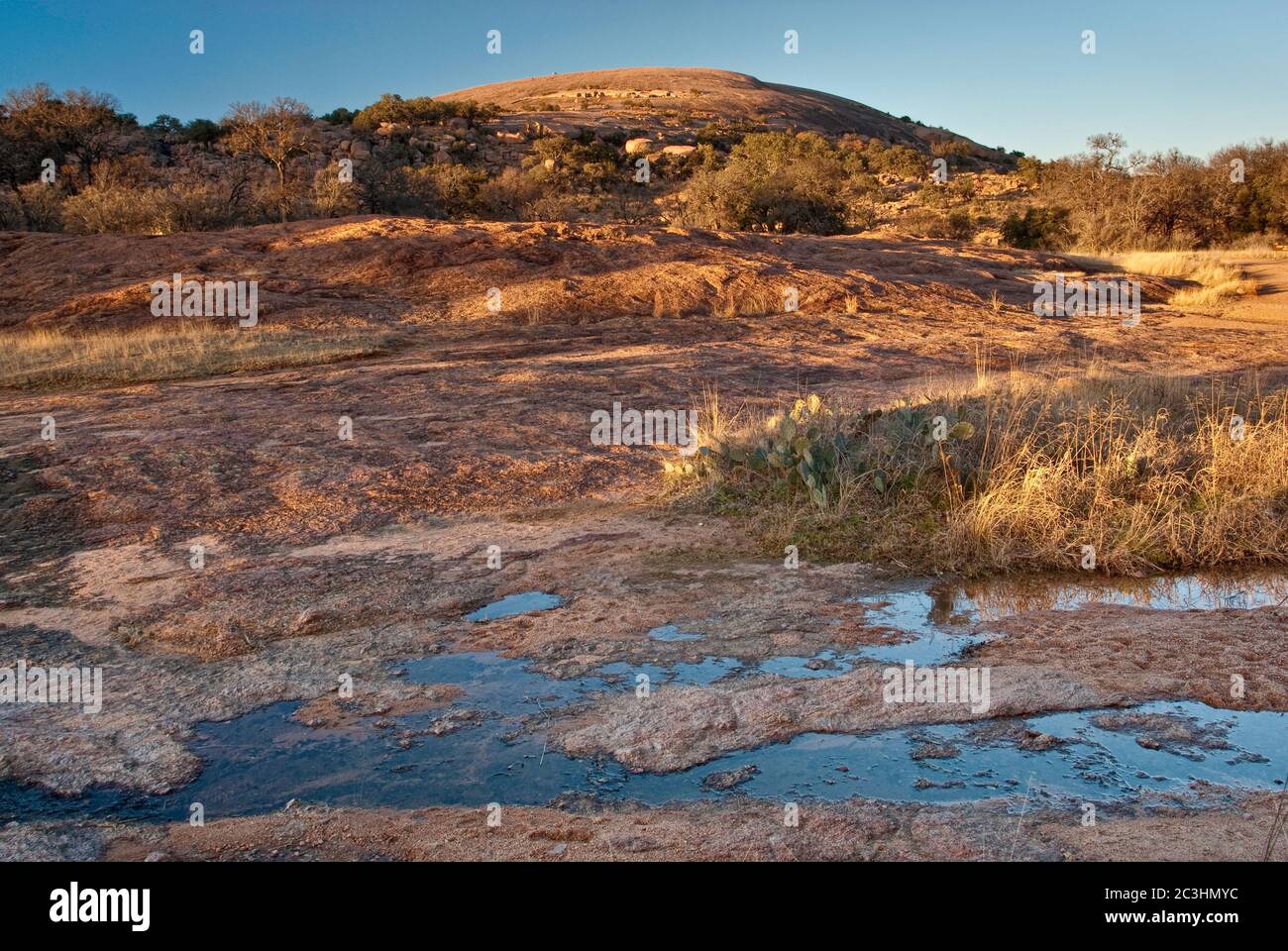 Main Dome al tramonto, ruscello dopo la recente pioggia, Enchanted Rock state Natural Area, in Hill Country vicino a Fredericksburg, Texas, USA Foto Stock