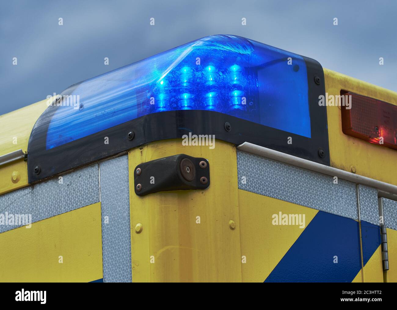 Primo piano di un furgone tedesco con luci di emergenza blu accese contro il cielo blu Foto Stock