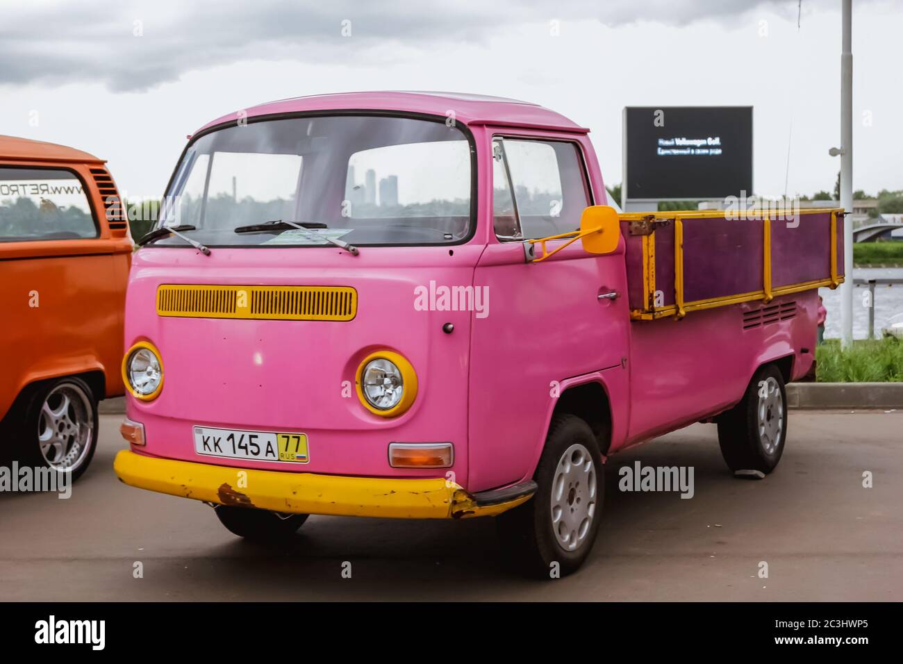 Mosca. Russia - 20 maggio 2019: Rosa e giallo Volkswagen trasportatore T2 pick-up Hippie bus sono parcheggiati sulla strada. Auto d'epoca Foto Stock