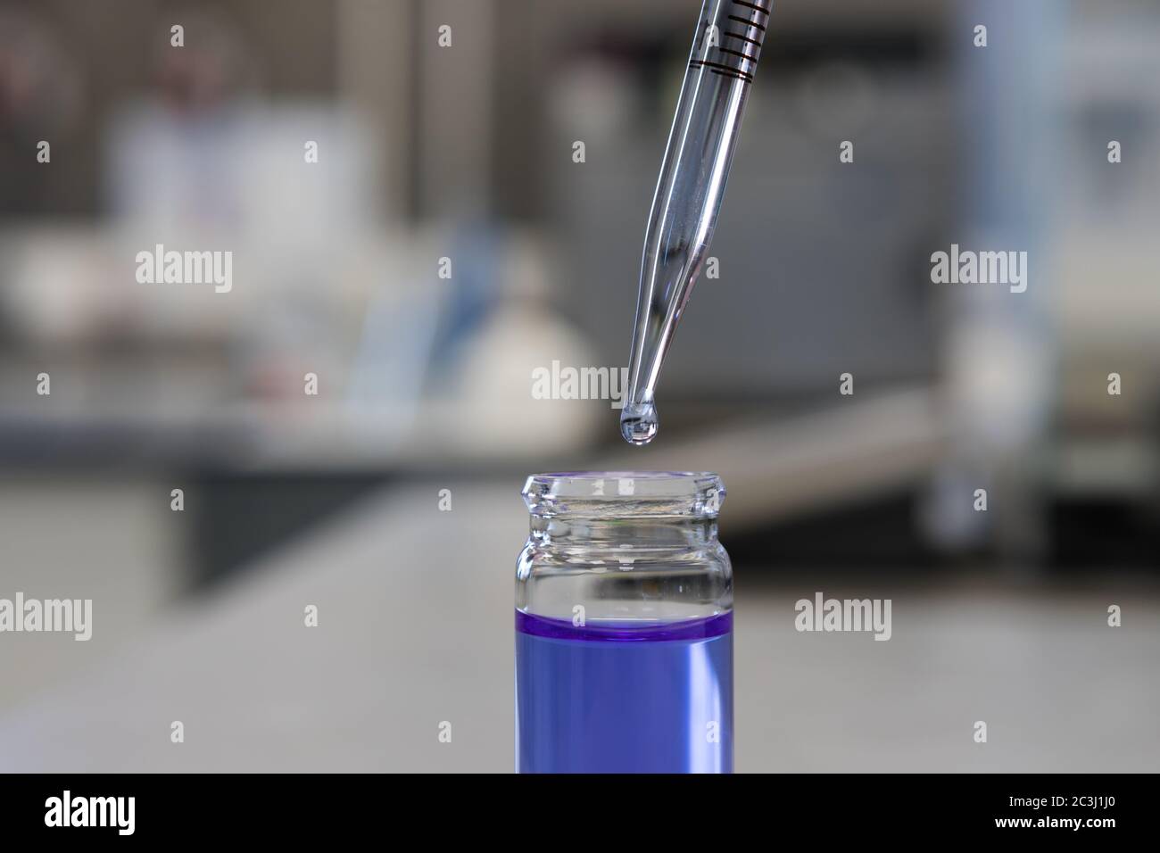 Utilizzando una pipetta in un laboratorio chimico per analizzare una soluzione chimica Foto Stock