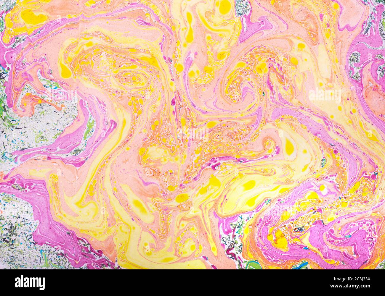 Fondo astratto realizzato con carta marmorizzata a mano, inchiostro giallo, arancione e rosa. Foto Stock