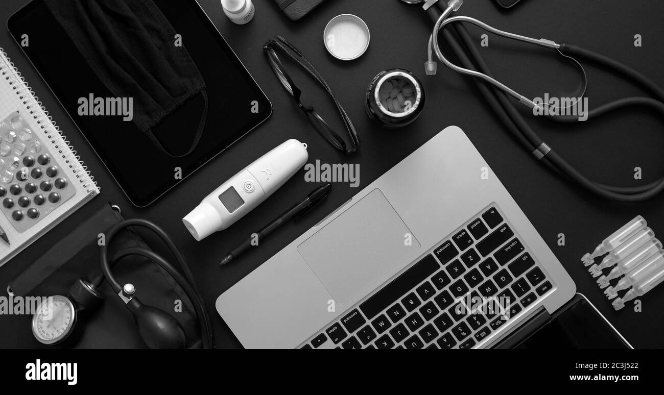 Concetto di desktop medico. Vari strumenti medici e accessori posizionati su un tavolo nero come mockup. Con laptop, medicina, stetoscopio, pressu Foto Stock