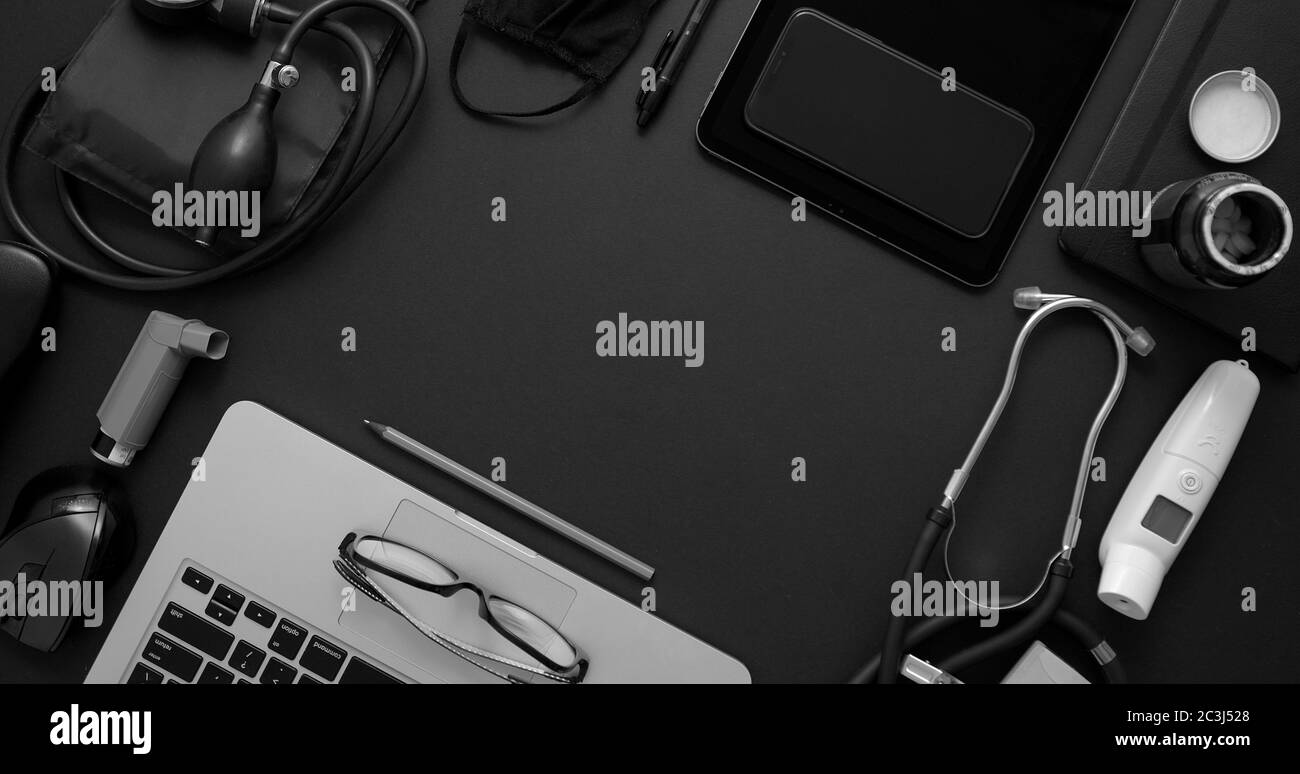 Concetto di desktop medico. Vari strumenti medici e accessori posizionati su un tavolo nero come mockup. Con laptop, medicina, stetoscopio, pressu Foto Stock