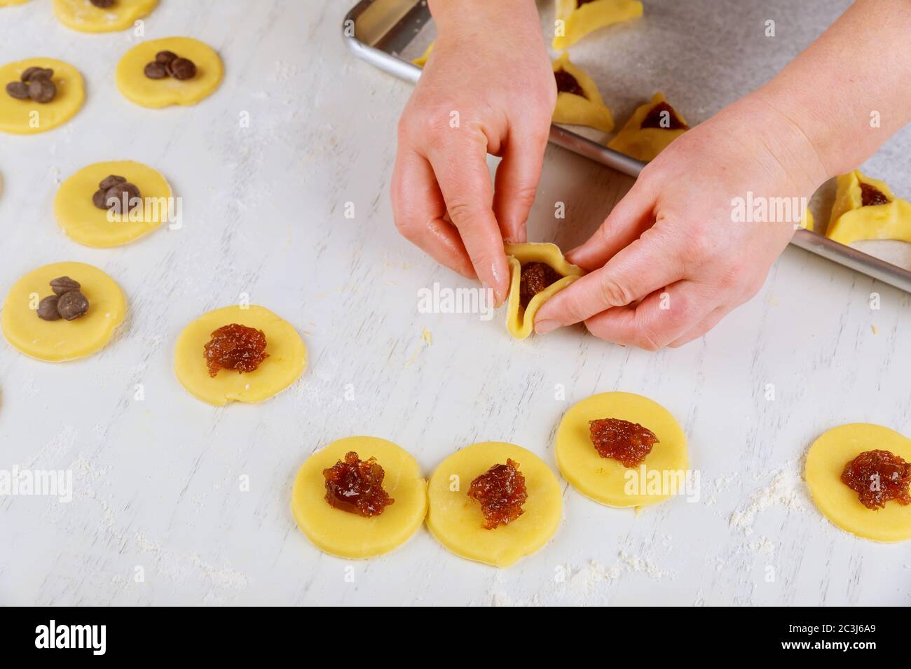 Preparare i biscotti hamantaschen con marmellata per Purim. Concetto di vacanza ebraica, Foto Stock