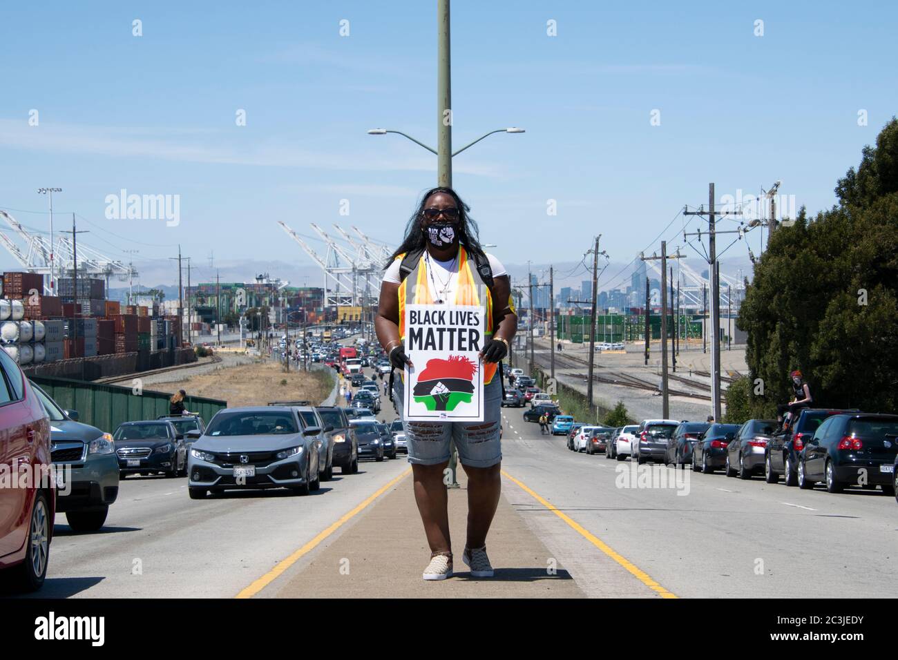 Un protetore porta un cartello 'Black Lives Matter' al Porto di Oakland il 19 giugno 2020. Foto Stock