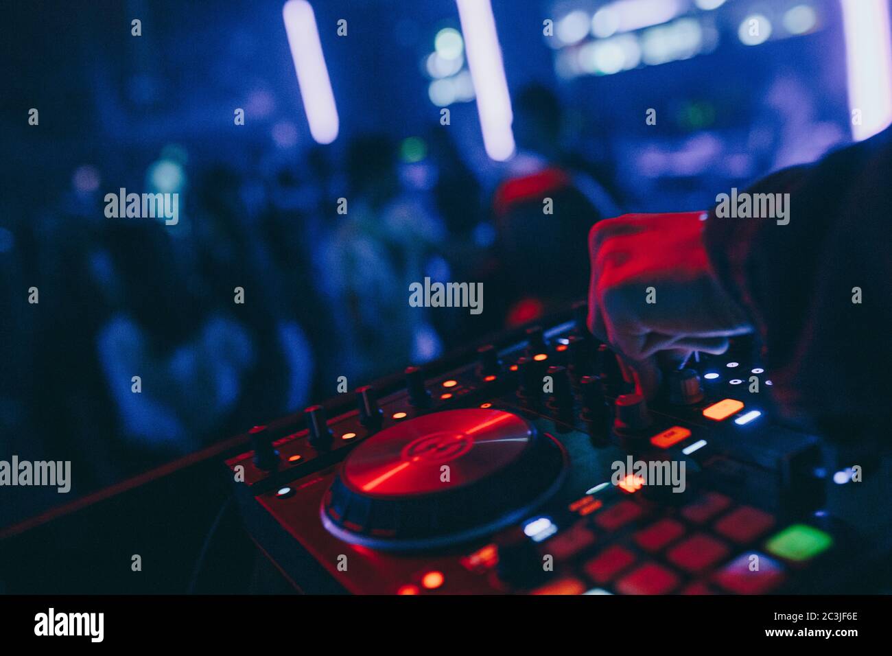 produttore DJ mixer in un nightclub con incandescente suona musica rave Dupasso Electronic Trance composizione con moderno midi controller dispositivo in nightlace Foto Stock