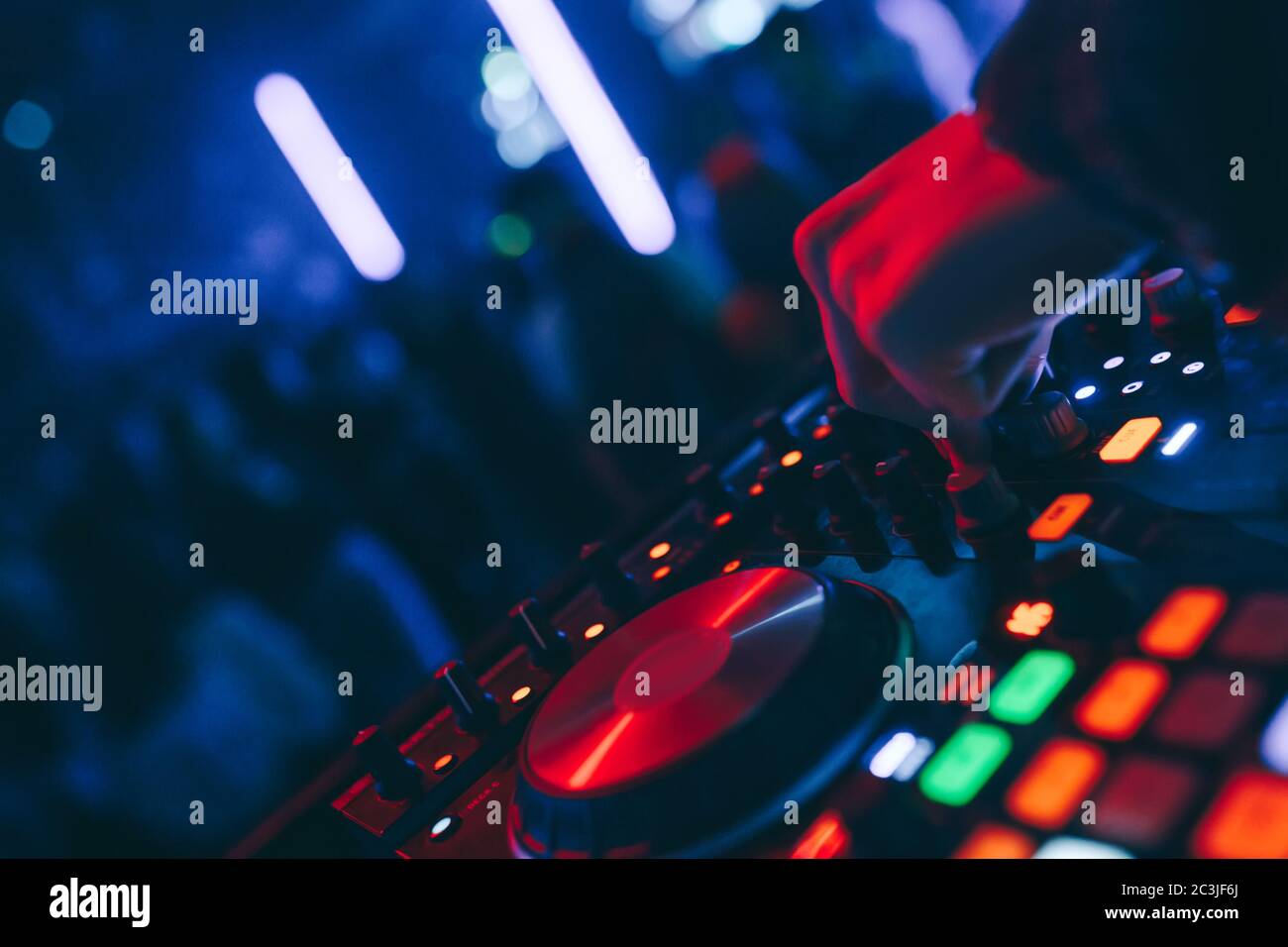 produttore DJ mixer in un nightclub con incandescente suona musica rave Dupasso Electronic Trance composizione con moderno midi controller dispositivo in nightlace Foto Stock
