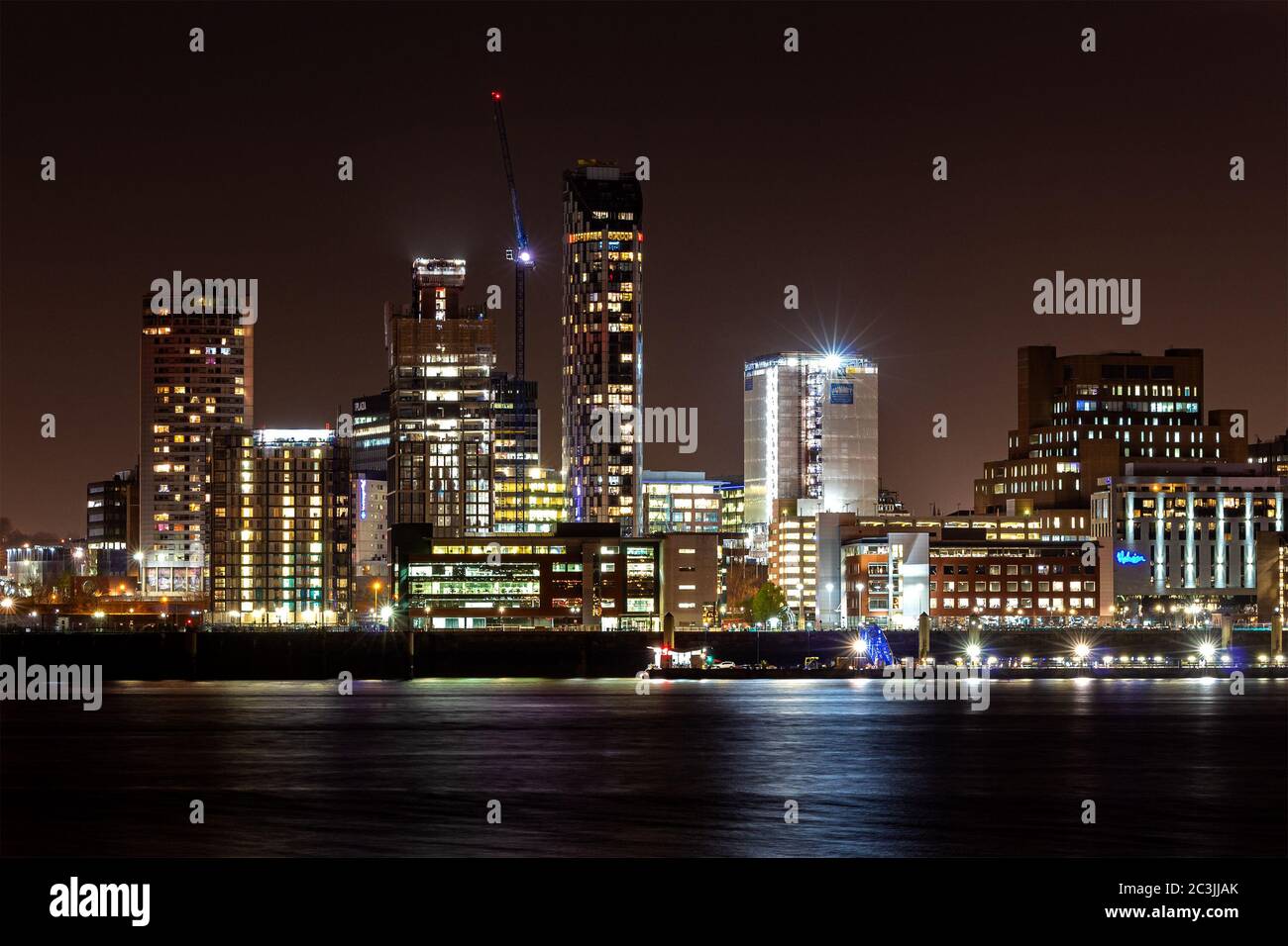 Skyline di Liverpool di notte. Edifici illuminati con vista sul fiume Mersey. Foto Stock
