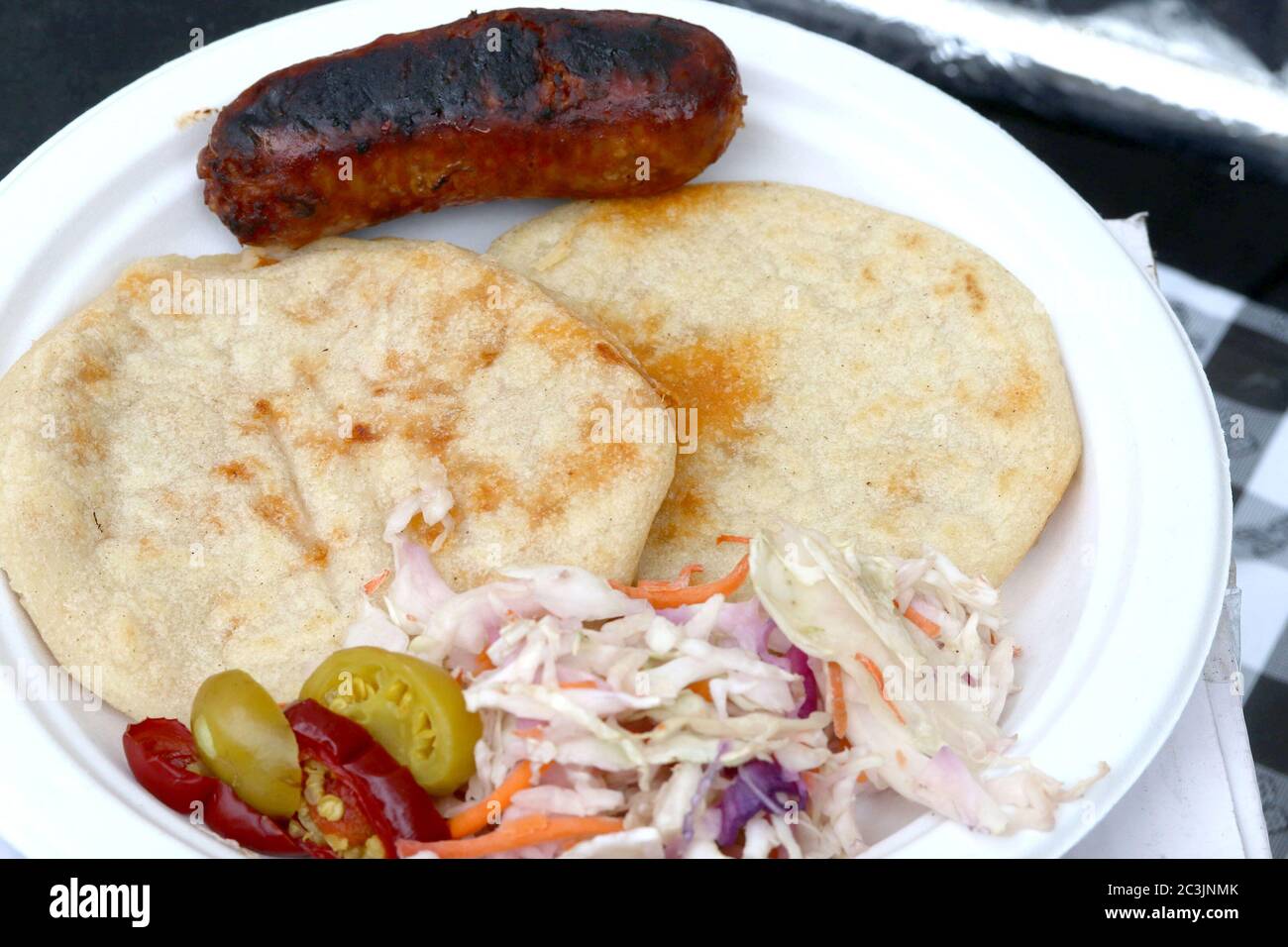 Tortillas di mais ripiene con ripieno di salato, servite con insalata di coleslaw piccante, peperoni caldi, salsa calda e chorizo Foto Stock