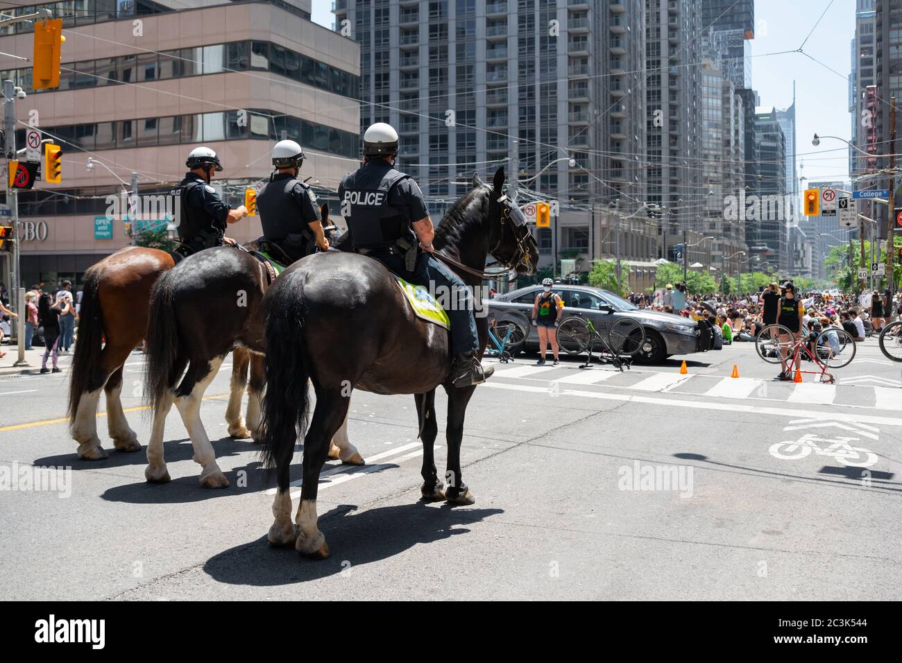 Ufficiali di polizia montati monitorano una protesta 'Not another Black Life' che occupa Bay e College Streets contro la brutalità della polizia a Toronto, Ontario. Foto Stock