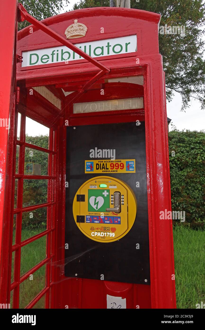 Defibrillatore in scatola telefonica britannica rossa, Marbury Village, Cheshire, Inghilterra, Regno Unito, AED, pronto soccorso cardiaco - salvavita Foto Stock