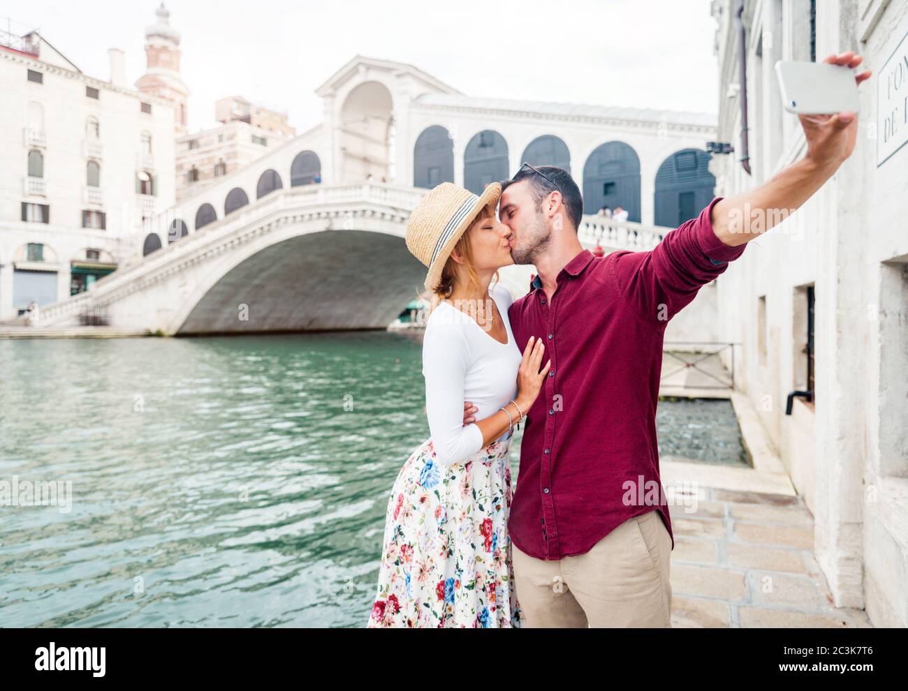 Una romantica coppia innamorata in vacanza a Venezia. I giovani si baciano  e prendono un selfie di fronte al Ponte di Rialto Foto stock - Alamy