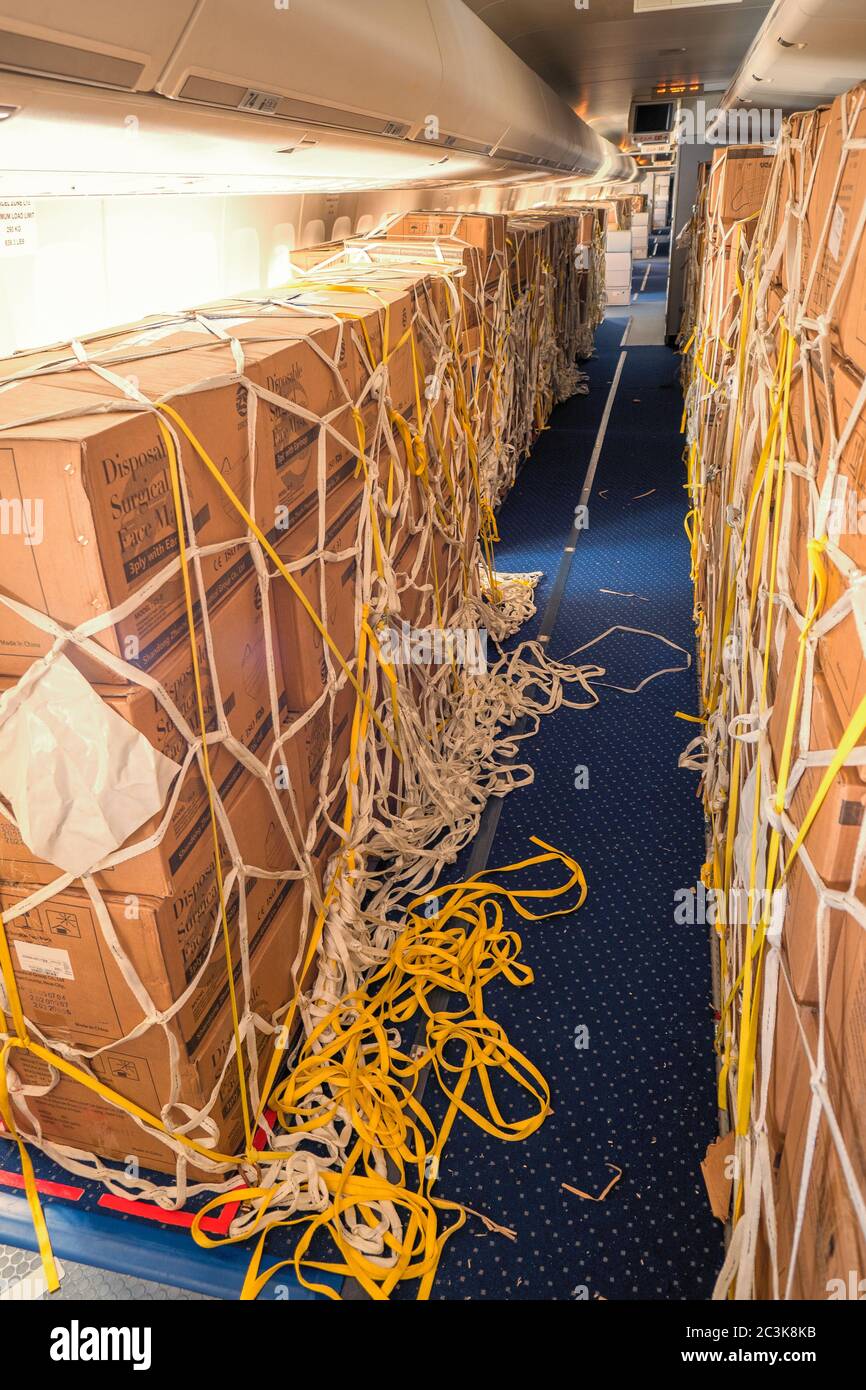 Vista interna di un passeggero convertito in aereo da carico Con scatole di maschere chirurgiche e camici dalla Cina a. Combattere la pandemia di COVID Foto Stock
