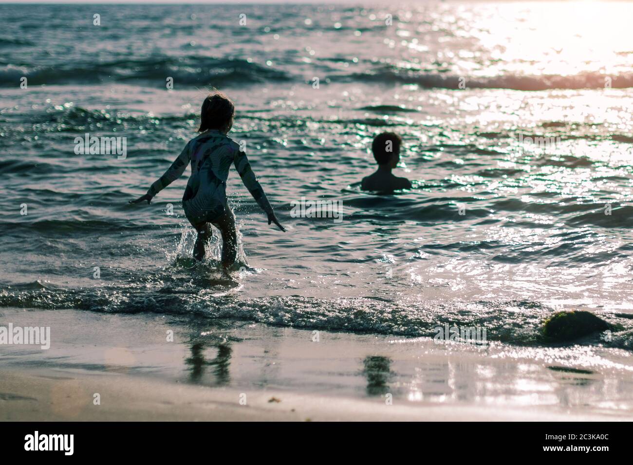 fratello e sorella in spiaggia al tramonto. Foto di alta qualità. Foto Stock