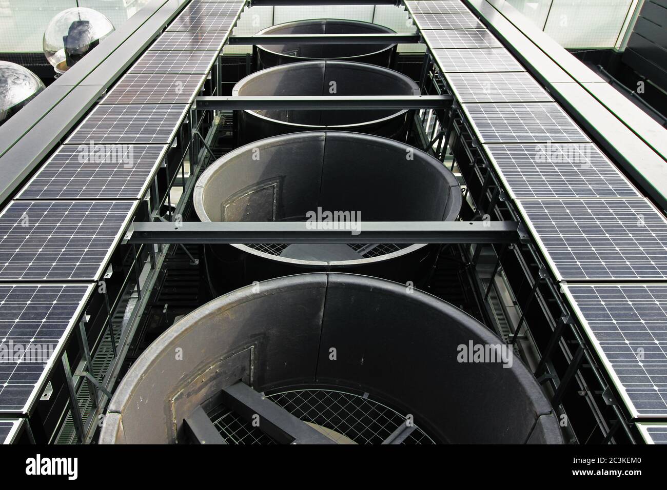 Attrezzature per esterni installate sul tetto di un grattacielo con grandi sfiati di scarico, pannelli solari e telecamere dal vivo Foto Stock