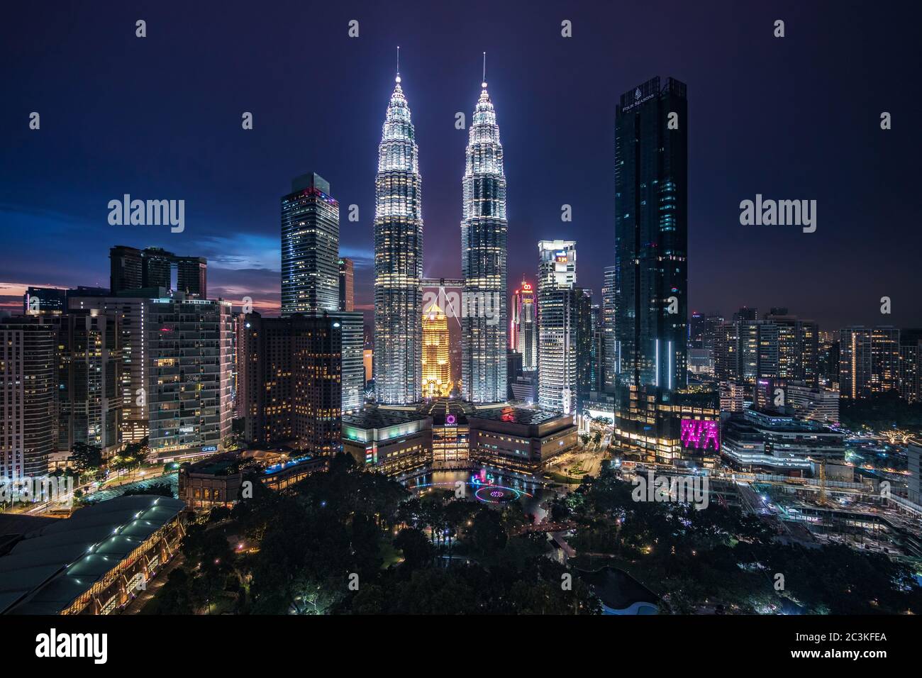 Kuala Lumpur City Centre, noto anche come complesso KLCC, che include le Torri Gemelle Petronas di notte a Kuala Lumpur, Malesia. Foto Stock