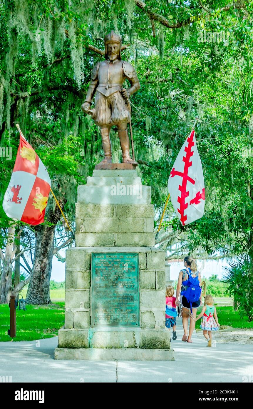 Una madre e i bambini camminano davanti alla statua di bronzo di Ponce de Leon al Parco Archeologico della Fontana della Gioventù di Ponce de Leon a St. Augustine, Florida. Foto Stock