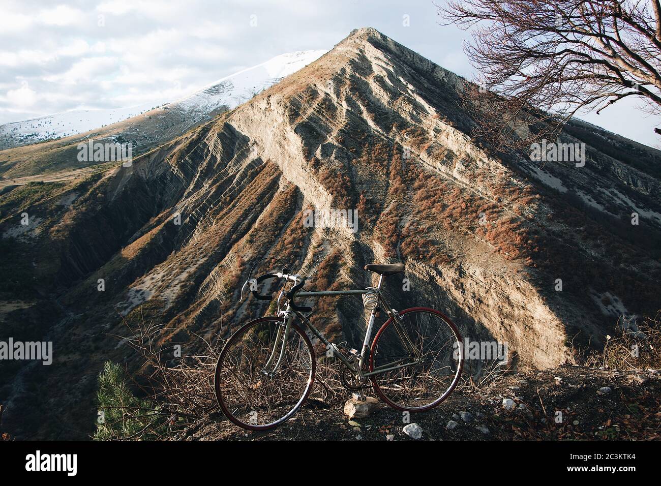 Vecchia bicicletta con le montagne sullo sfondo Foto Stock