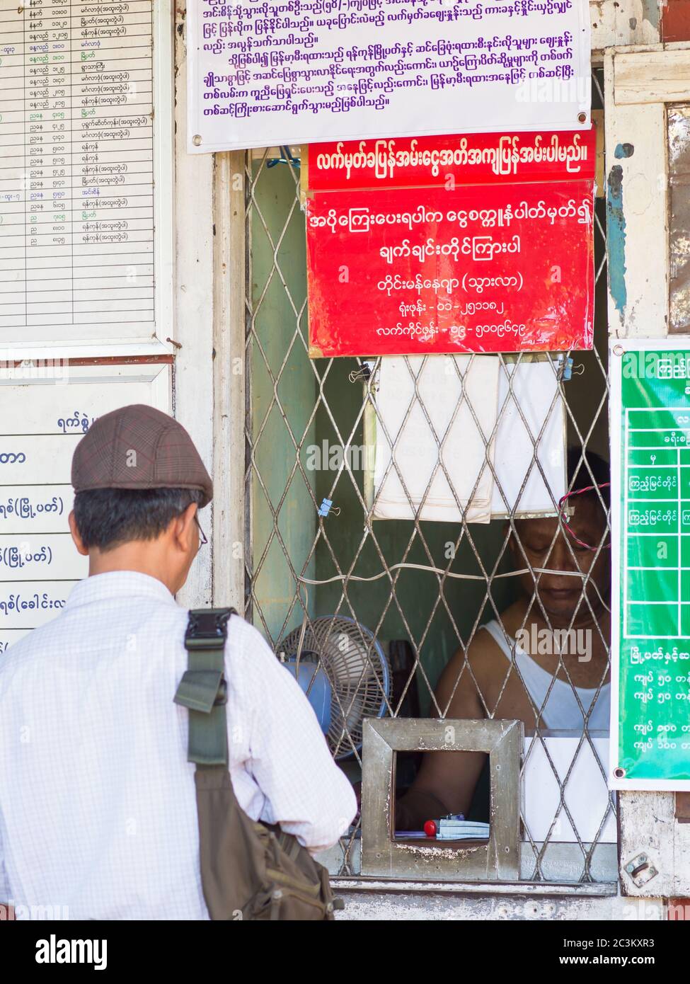 Yangon, Myanmar - 13 novembre 2014: Uomo che acquista un biglietto alla stazione ferroviaria di Pan Hlaing a Yangon, Myanmar. Myanmar ha una grande rete ferroviaria, ma st Foto Stock