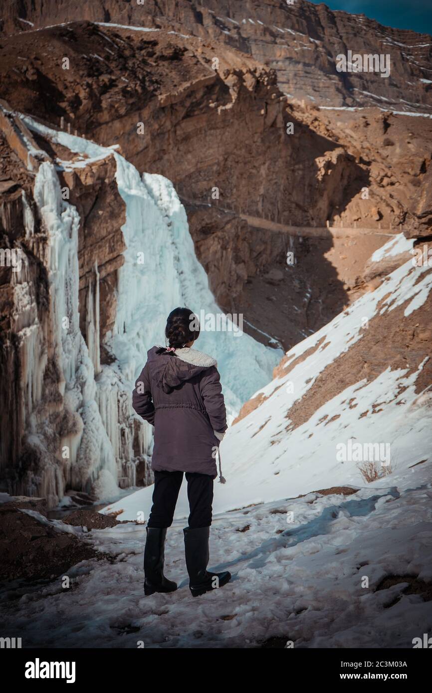 Ripresa verticale di una femmina che guarda la cascata congelata In Valle Spiti Foto Stock