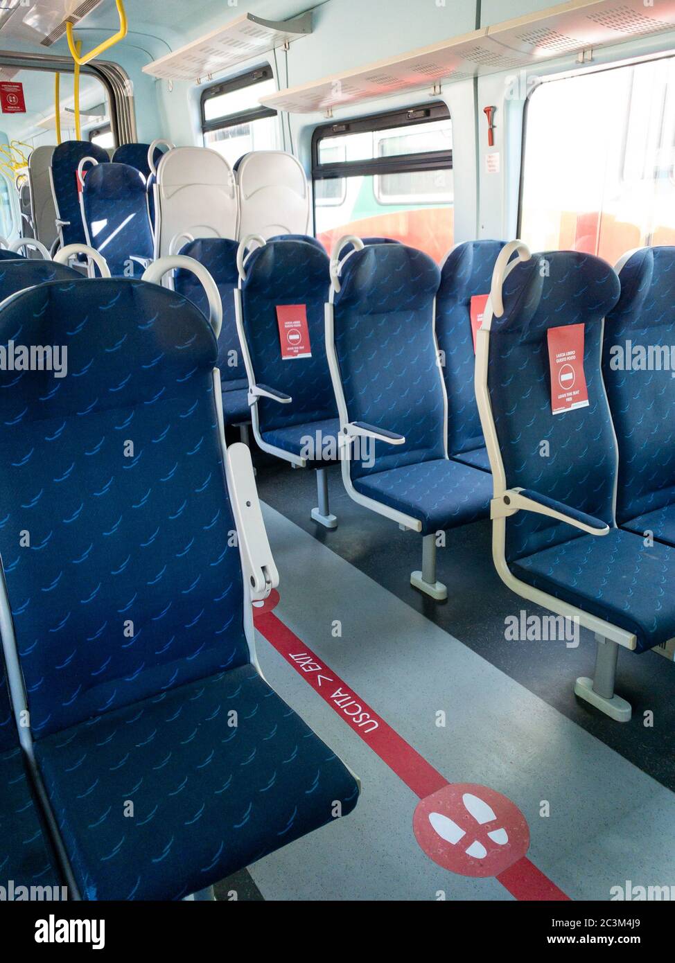 Mantova, Italia - 20 giugno 2020: treno trenitalia con cartelli rossi sui sedili che dicono di lasciare il posto libero, nuove regole di distanza dovute al coronavirus pan Foto Stock