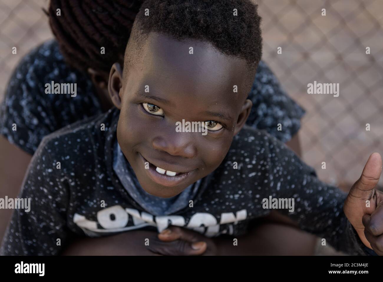 Un bambino africano rifugiato che vive sulla strada di Città del Capo dopo la sua sfratto da parte della polizia sudafricana e senza la fornitura di alloggi alternativi Foto Stock