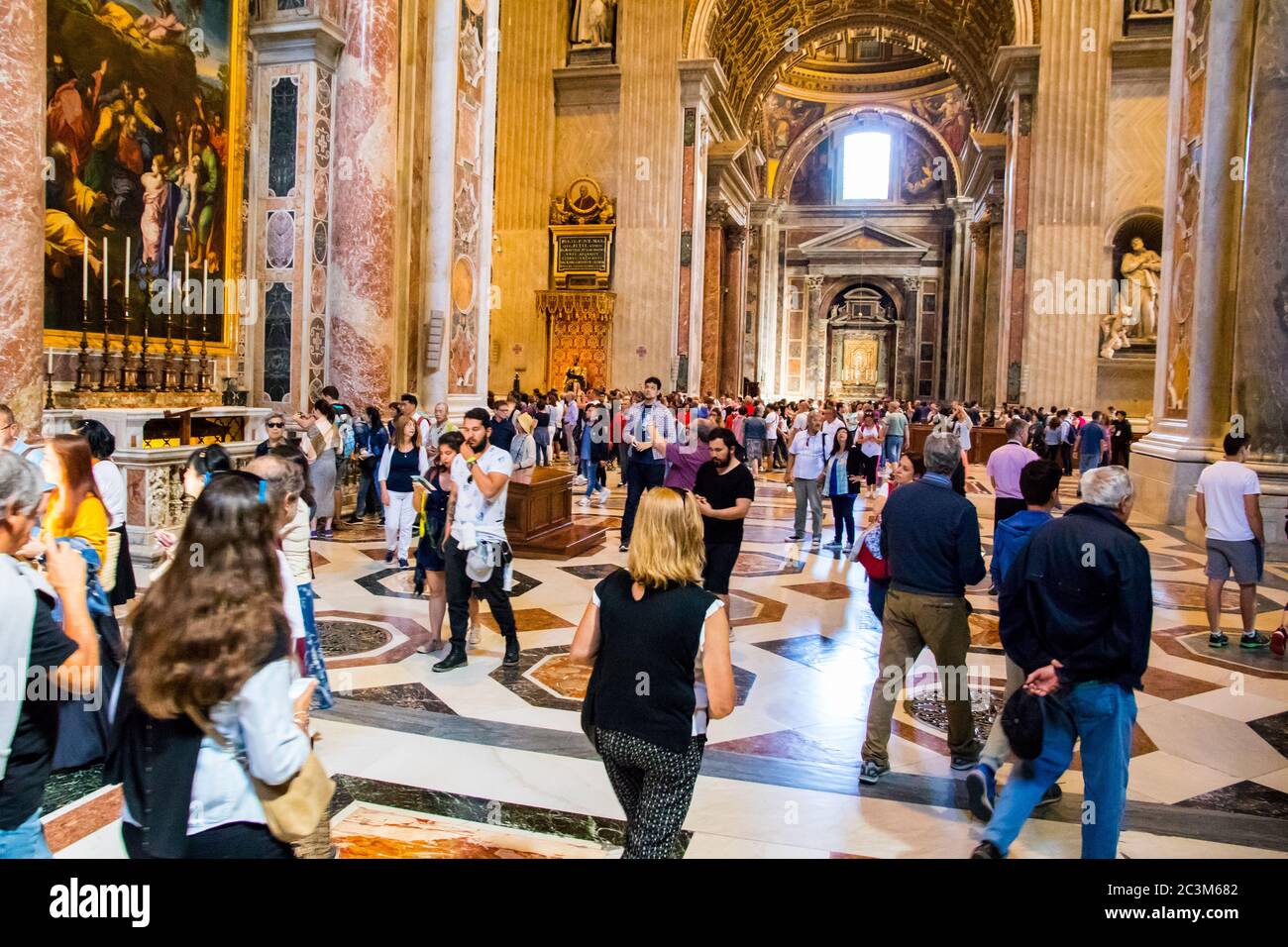 Turisti e pellegrini che si affollano nella Basilica di San Pietro in Vaticano Foto Stock
