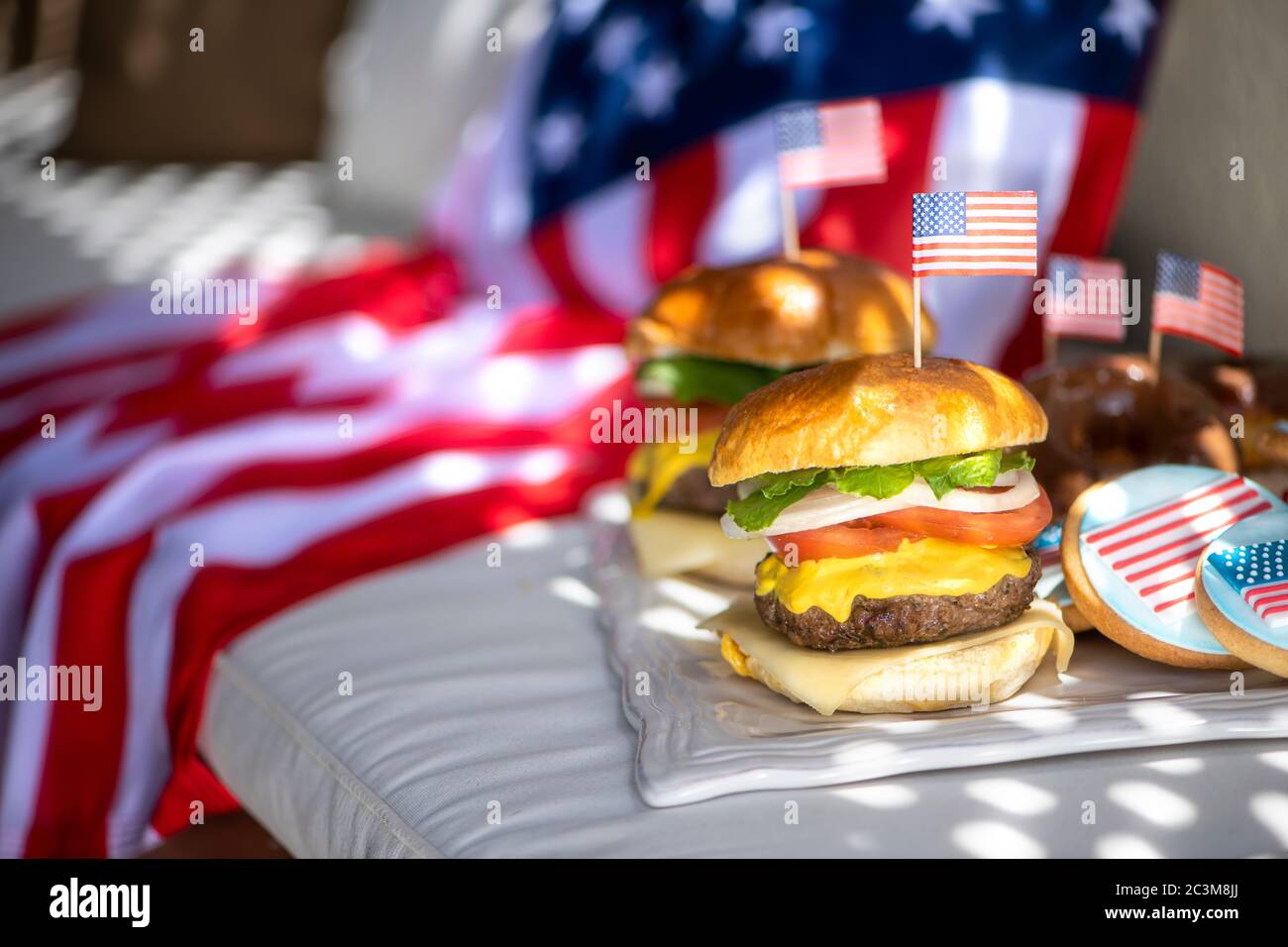 Due hamburger americani con bandiera americana su di loro e una bandiera americana per sfondo per il 4 luglio Foto Stock