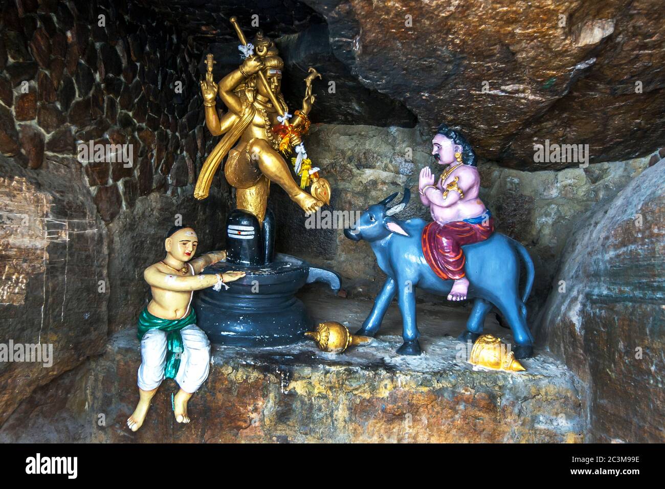 Una grotta a Koneswaram Kovil a Trincomalee in Sri Lanka che raffigura quattro dea indù armata Lakshmi e due devoti. Foto Stock