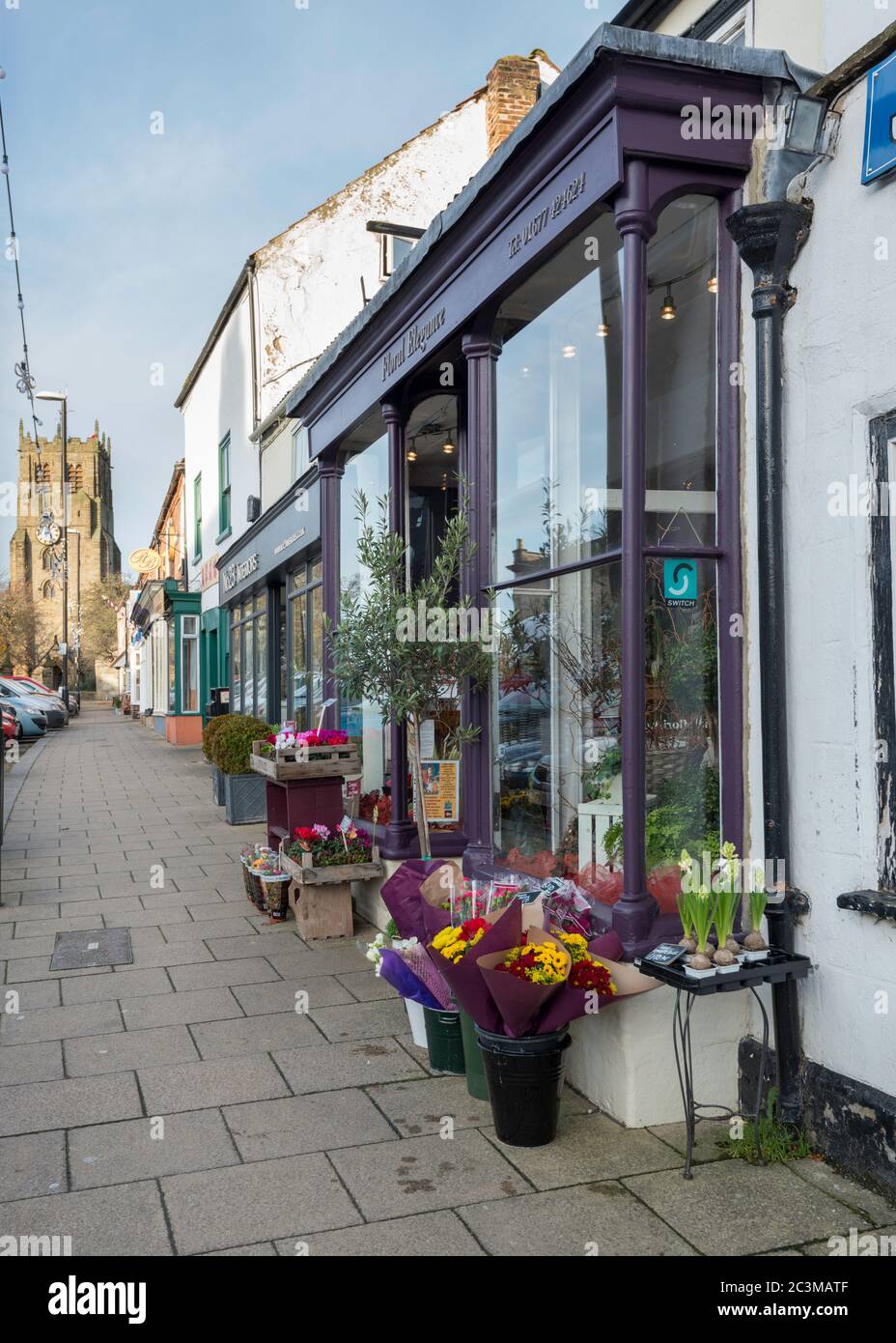 Ammira i negozi di fiori verso la torre della chiesa nella città di Bedale, nel North Yorkshire Foto Stock